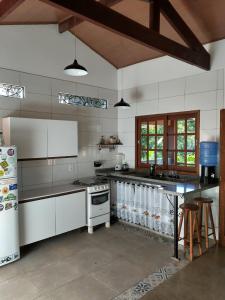伦索伊斯Casa Colmeia的厨房配有白色家电和桌子