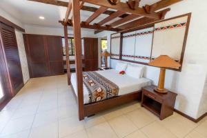 拉奇拉奇Villa Vanua - Private Luxury Villa的一间卧室,卧室内配有一张天蓬床