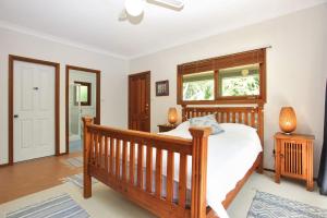 霍克斯内斯特Semaphore Beach House的一间卧室设有一张木床和一个窗户。