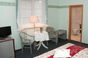 巴特萨罗皮斯库夫埃姆威尔酒店的酒店客房设有桌椅和一间卧室。