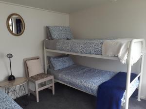 芒阿法埃Quail's Nest的一间卧室配有两张双层床和椅子
