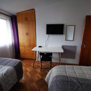 康塞普西翁Hostal Vivo Concepción的一间卧室配有书桌、电视和床。
