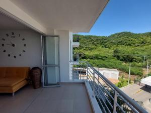 吉拉尔多特Apartamento Aqualina Orange Piso 5 Vista a Montañas 2 Habitaciones的阳台,墙上有时钟,沙发