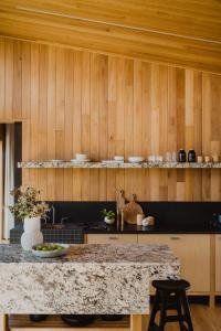 丹马克Upland Farm Luxury Cabins, Denmark Western Australia的厨房设有柜台和木墙