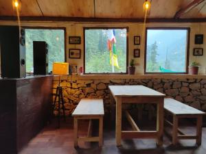 吉布Himtrek Camps Jibhi的一间设有两张桌子和一个柜台的房间,窗户