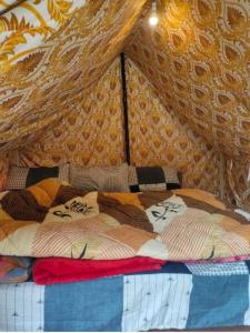 吉布Himtrek Camps Jibhi的一张带一束毯子和枕头的床