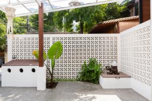 清迈清迈萱格旅馆的庭院上种有植物的白色围栏