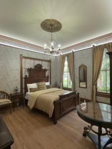 圣奥古斯丁1001 Nights Historic Bed and Breakfast Adults Only的一间卧室配有一张床、一张桌子和一个吊灯。