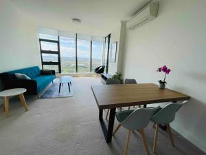悉尼Panoramic City View 3bed2bath condo Wi-Fi Parking的客厅配有桌子和蓝色沙发