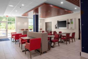 威尔斯Holiday Inn Express - Wells-Ogunquit-Kennebunk, an IHG Hotel的用餐室配有桌子和红色椅子