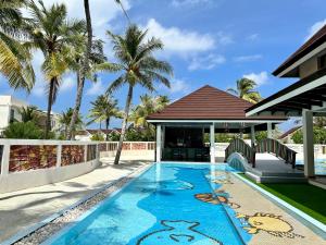 马累OBLU XPERIENCE Ailafushi - All Inclusive with Free Transfers的棕榈树屋前的游泳池