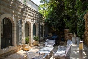 耶路撒冷Cozy Heritage Home Jerusalem的一个带桌椅的庭院和一座建筑