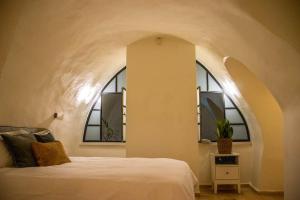 耶路撒冷Cozy Heritage Home Jerusalem的卧室配有白色的床和2扇窗户。
