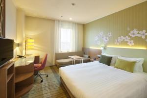 武藏野Kichijoji Excel Hotel Tokyu的酒店客房设有一张大床和一张书桌。