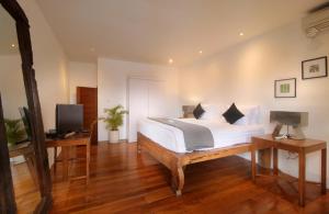 坎古坎古公寓酒店的一间卧室配有一张床、一张书桌和一台电视