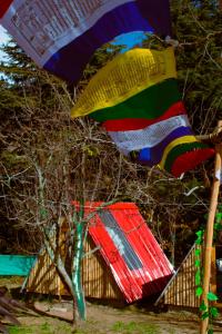 马拉里SGM Camp & Cottage的一把五彩缤纷的雨伞飞过房子