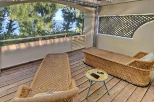 拉萨尔勒班La villa Caroline - La Saline les Bains的阳台配有藤椅和桌子