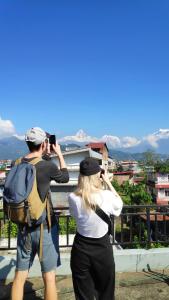 博卡拉Hotel Mountain View - Lakeside Pokhara的男人用相机拍女人的照片