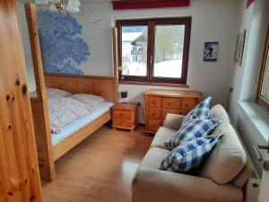 蒂罗尔州圣约翰Bauernhaus im Permakultur-Garten的一间卧室配有一张床、一张沙发和一个窗口