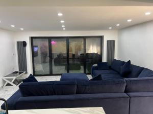 伯明翰Penthouse Style Luxury 2 Bedroom House has Hot-Tub, extra fees apply的客厅设有蓝色的沙发和大窗户