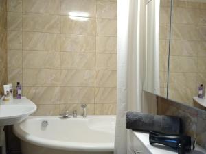 马多纳Sunrise Apartment的浴室配有盥洗盆、卫生间和浴缸。