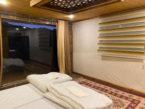 瓦迪拉姆Desert Jewel Camp的窗户前设有两张床的房间