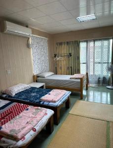 Fang-liao枋寮枋居背包客棧Fang Ju Backpackers的带3张床和2个地毯的房间