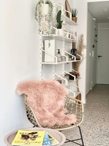 奥斯坦德Theodore Oostende-zorgeloos genieten in stijl op de perfecte locatie的一间带粉色毯子椅子的房间
