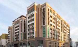 多哈La Maison Hotel Doha的一座高大的建筑,城市里有很多窗户