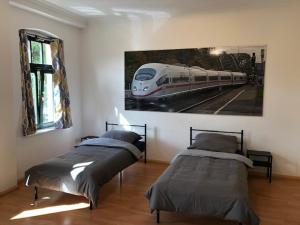爱尔福特Ferienwohnung Nordluft的一间卧室配有两张床,还有一幅火车画