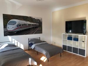 爱尔福特Ferienwohnung Nordluft的一间卧室设有两张床,墙上挂有火车画