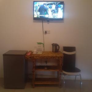 卡萨内Sunshinevibe guest house的一间房间,墙上有桌子和电视