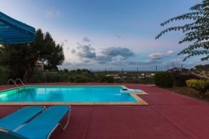 马鲁拉斯Maroulas Villa Estate的大型游泳池设有2把蓝色椅子
