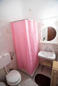 加拉希德松Koukonas的浴室设有粉红色的淋浴帘和水槽
