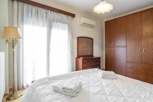 亚历山德鲁波利斯4 Seasons Home的一间卧室配有一张大床和两条毛巾
