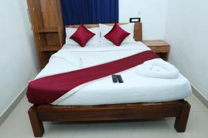 安加马尔伊Airport Cochin Grand Residency , NEDUMBASSERY的一张铺有红白床单和红色枕头的床