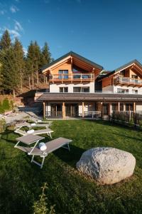 安达洛La Dila Dolomiti Mountain Lodge的一个带躺椅的庭院