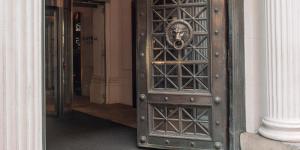 巴塞罗那Grand Hotel Central, Small Luxury Hotels的老木门,上面有狮子头