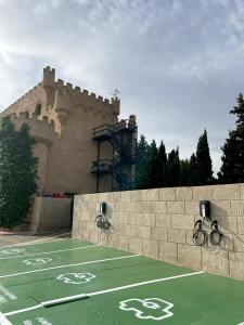 佩多拉卡斯蒂略博纳维亚酒店的一座城堡,在一座建筑前设有一个网球场