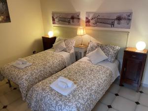 梅萨涅Porta Piccola B&B的两张位于酒店客房的床,配有毛巾