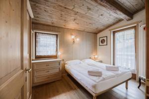 坎皮泰洛迪法萨Cesa Linda的一间卧室设有一张床和木制天花板