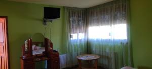 科泰尔Hotel Ambrozia的绿色的客房设有电视、桌子和窗户