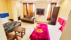 阿姆利则Hotel Sukhman Residency的客房设有两张床、一张沙发和一台电视。