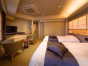 富士吉田市Kaneyamaen的酒店客房设有两张床和电视。