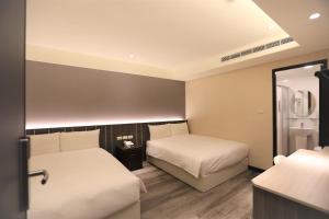 台北城美行旅的一间卧室配有两张床和镜子