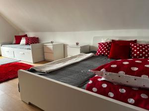 TiszabábolnaPöttyösOtthon Vendégház的一间卧室配有一张带红色和白色枕头的大床