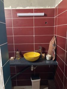 Le SouffleurYeux D'azur的柜台上的浴室设有黄色的碗水槽