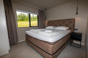 阿克雷里North Mountain View Suites的一间卧室设有一张大床和一个窗户。