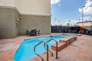 休斯顿Comfort Suites near Texas Medical Center - NRG Stadium的一个带桌椅的大型游泳池