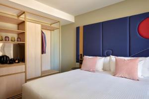 墨尔本Quincy Hotel Melbourne的一间卧室配有一张大床和蓝色床头板